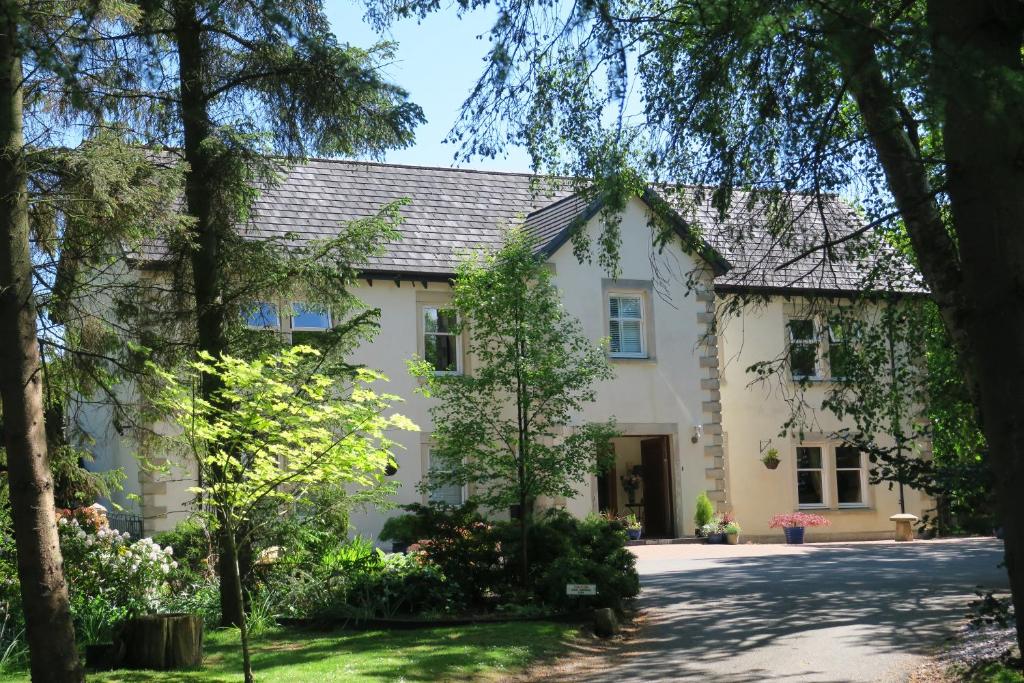 una casa blanca con árboles delante de ella en Arden Country House, en Linlithgow