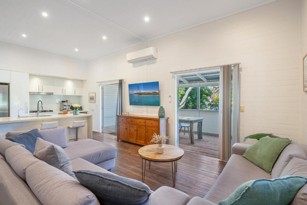a living room with a couch and a table at Cove Quarters in Byron Bay