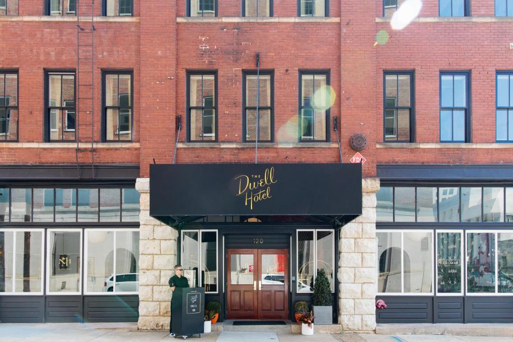 un hombre parado frente a un edificio de ladrillo en The Dwell Hotel, a Member of Design Hotels, en Chattanooga