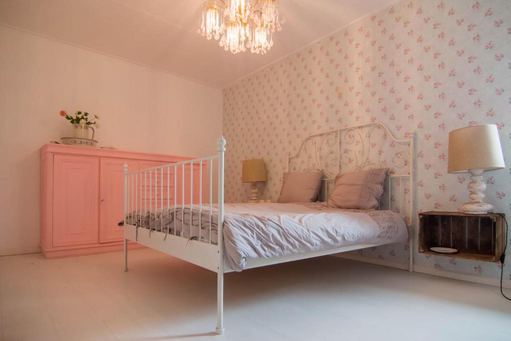 een slaapkamer met een wit bed en een roze muur bij Brigidahoeve in Maastricht