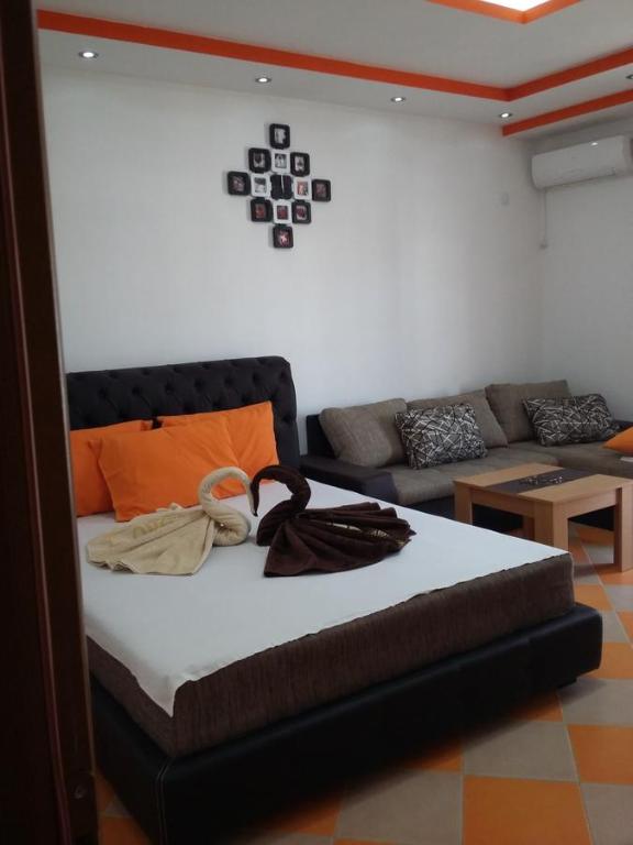 a bed in a living room with a couch at Apartments Aza in Dobra Voda