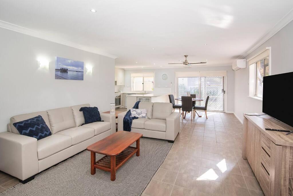 a living room with a couch and a table at Jetty Views -100m to foreshore in Busselton