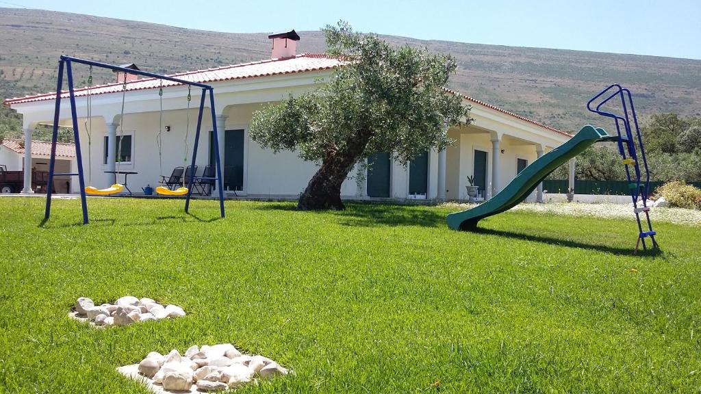 un patio con dos columpios y un tobogán en Casa Das Oliveiras en Alvados