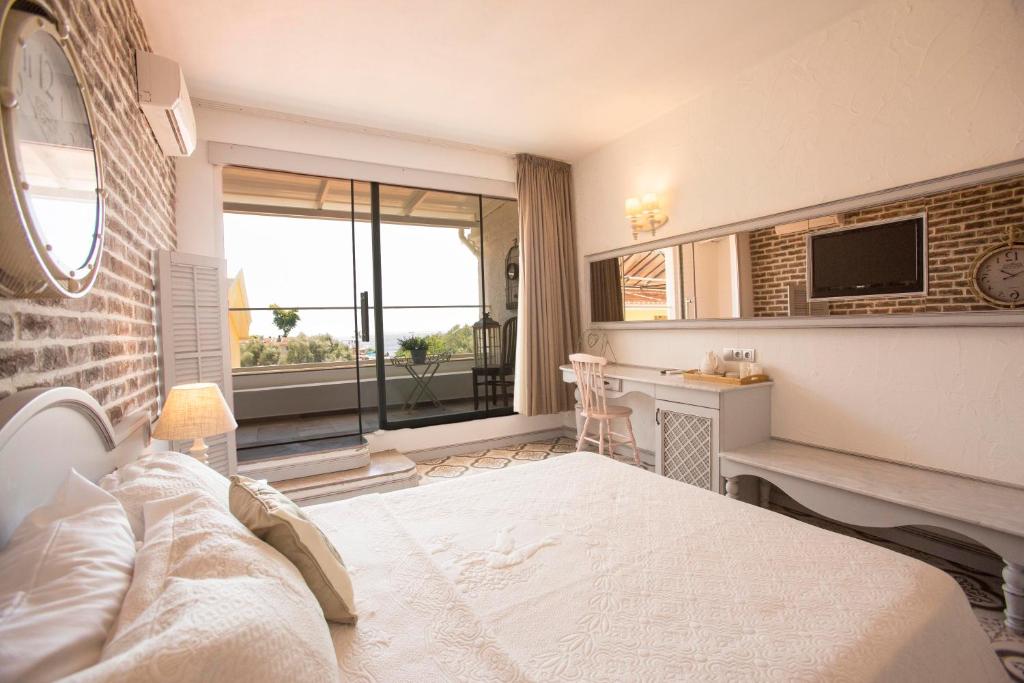 Dormitorio con cama, escritorio y TV en S3 Hotels Orange, en Ölüdeniz