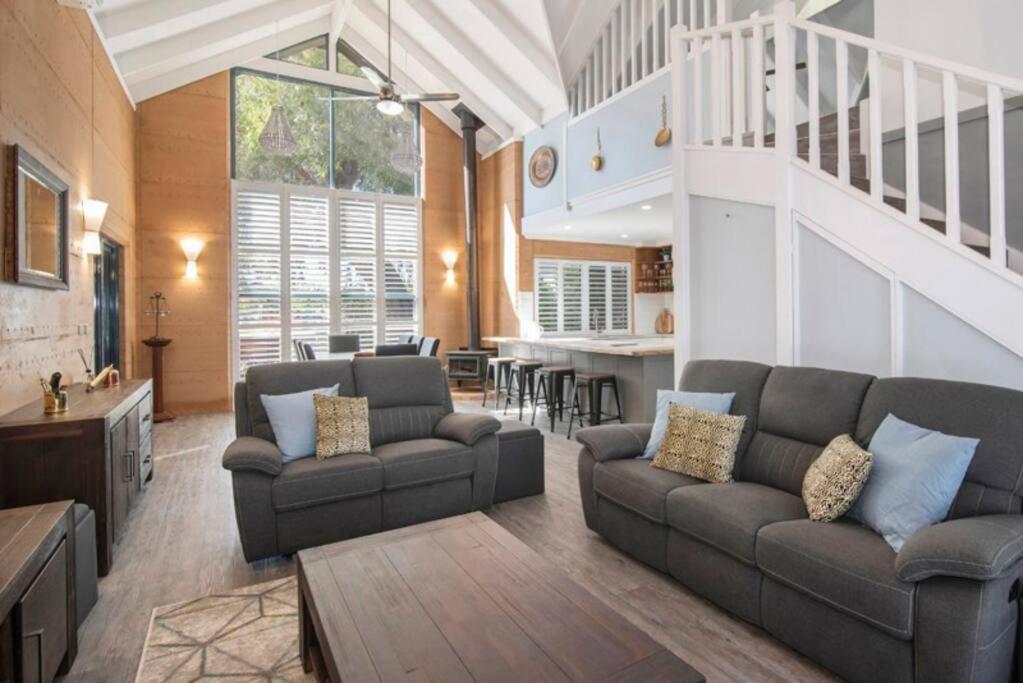 a living room with two couches and a table at Sea Breeze Villa in Dunsborough