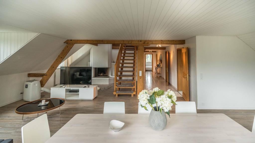 a dining room with a table with a vase of flowers at Löwenplatz Apartment near Station by Airhome in Zurich