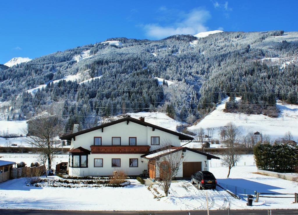 uma casa na neve em frente a uma montanha em Frühstückpension Larson em Bad Hofgastein