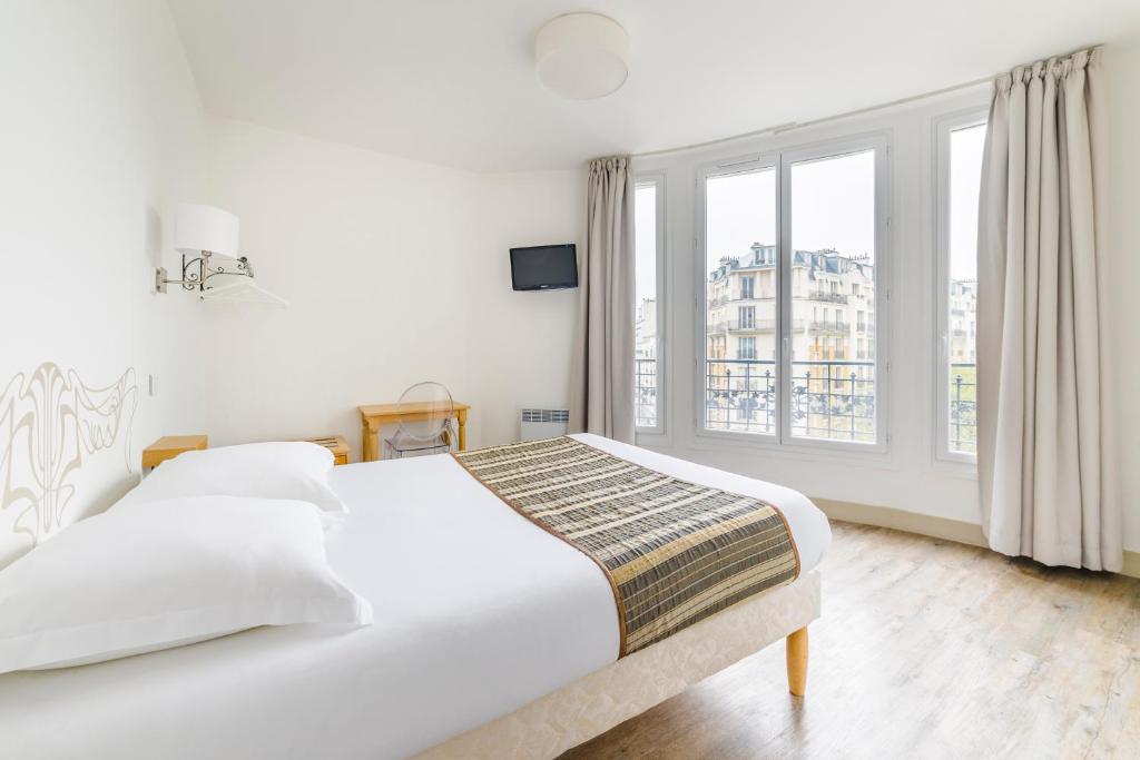 um quarto branco com uma cama e uma grande janela em Hotel Korner Eiffel em Paris
