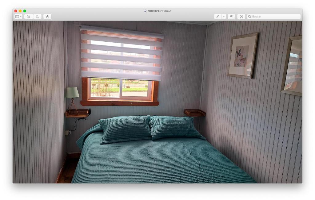 a bedroom with a bed and a window at Zenteno Osorno Apartment in Osorno