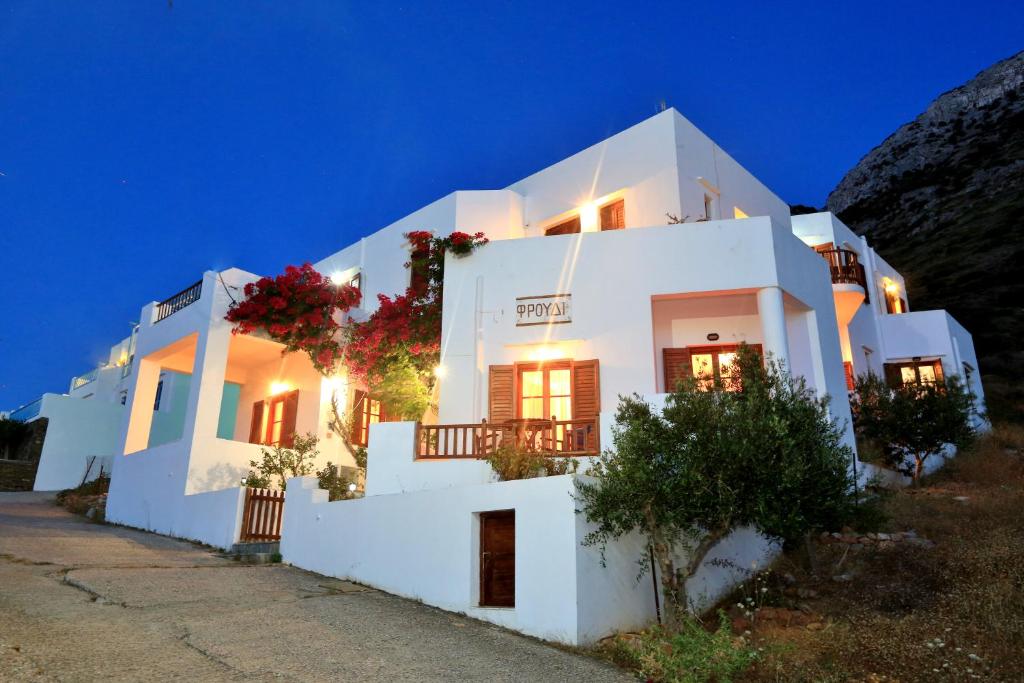 a white building with flowers on it at night at Froudi Rooms in Kamares