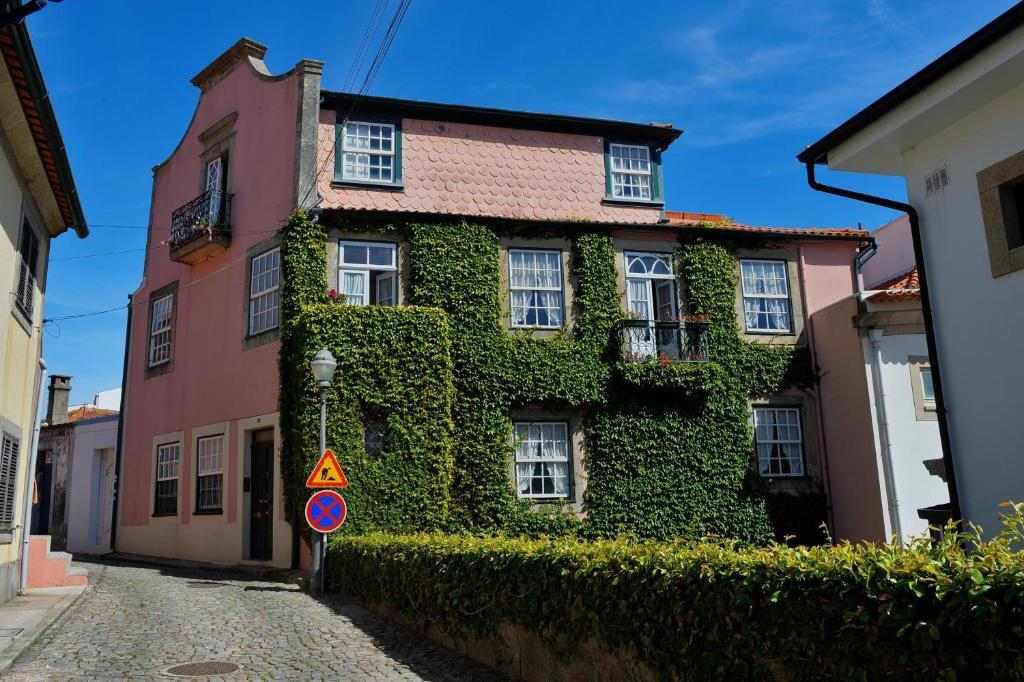 un edificio cubierto de hiedra junto a una calle en Casa da Belavista, en Oporto