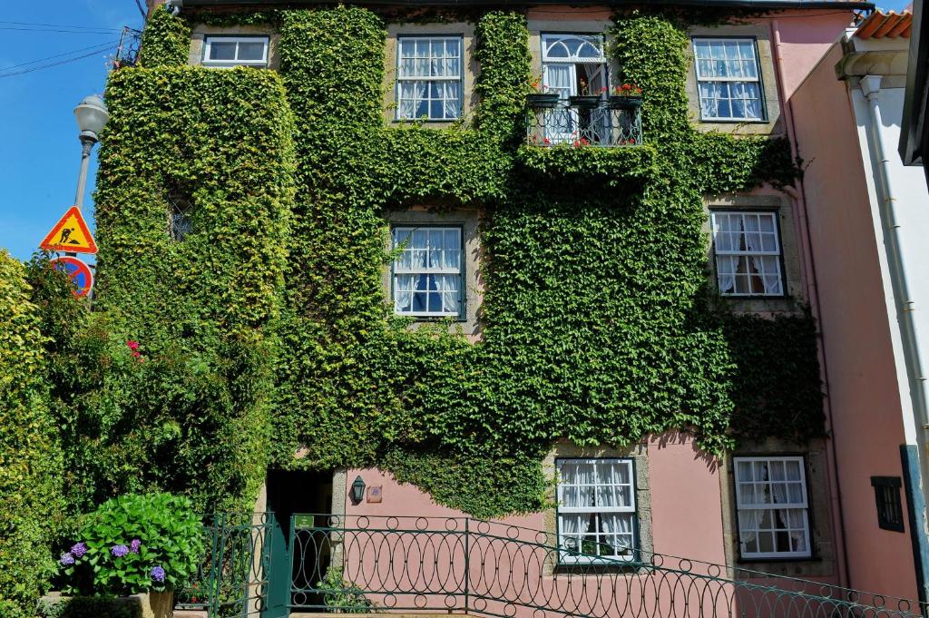 a building covered in green ivy next to a building at Casa da Belavista in Porto