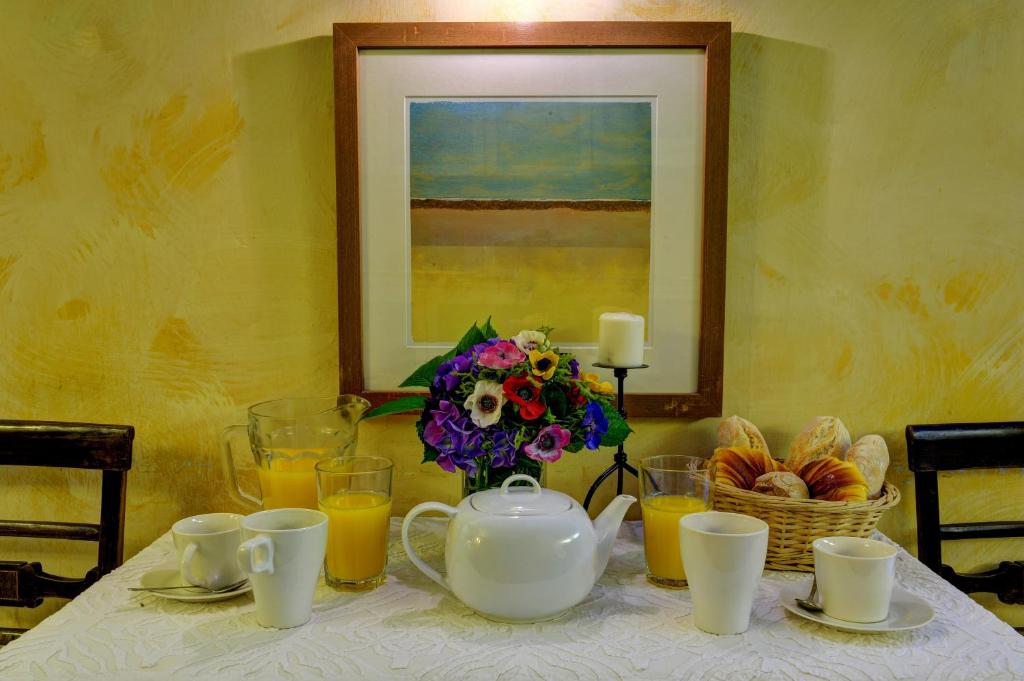 a table with a tea pot and a vase of flowers at Casa da Belavista in Porto