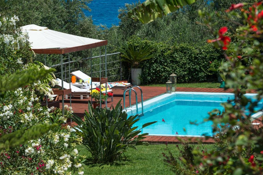 a swimming pool in a yard with a umbrella at Gialou studio in Akrotiri