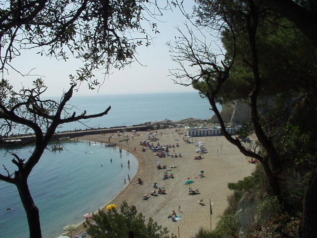 eine Gruppe von Menschen an einem Strand in der Nähe des Wassers in der Unterkunft Grazioso Appartamento Panoramico in Sirolo