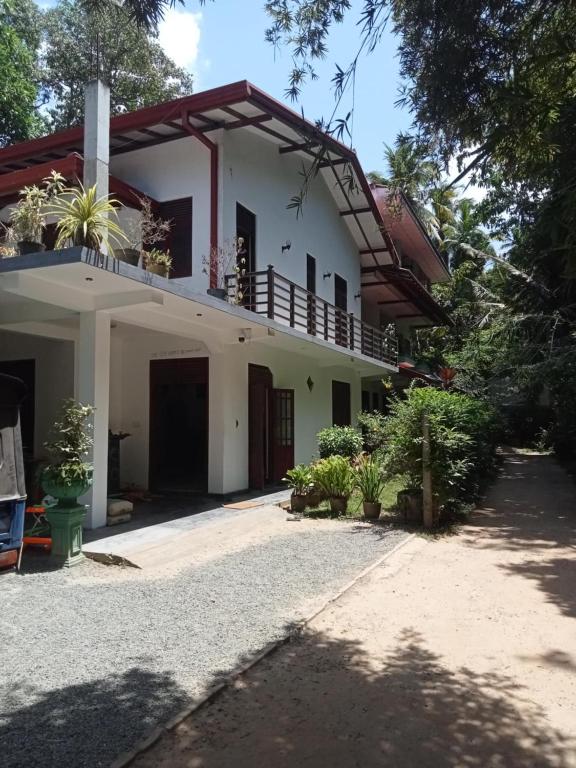 a large white house with a balcony at Piumi House in Hiriketiya