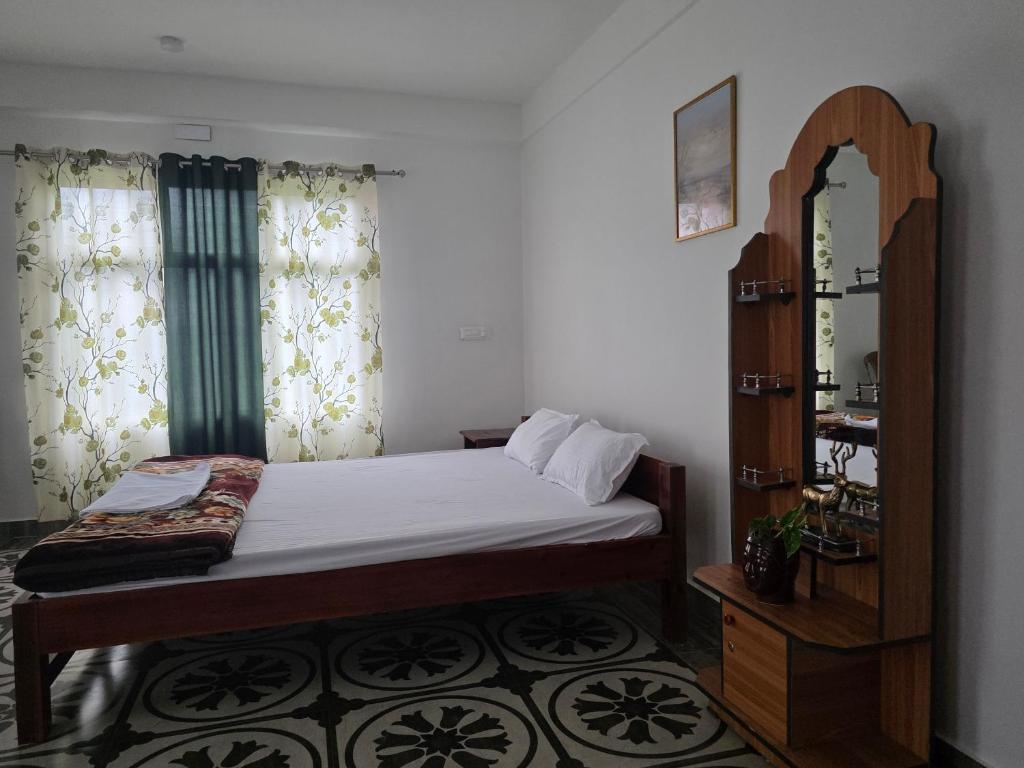 a small bedroom with a bed and a mirror at Bagalay Homestay Mungpoo in Mangpu