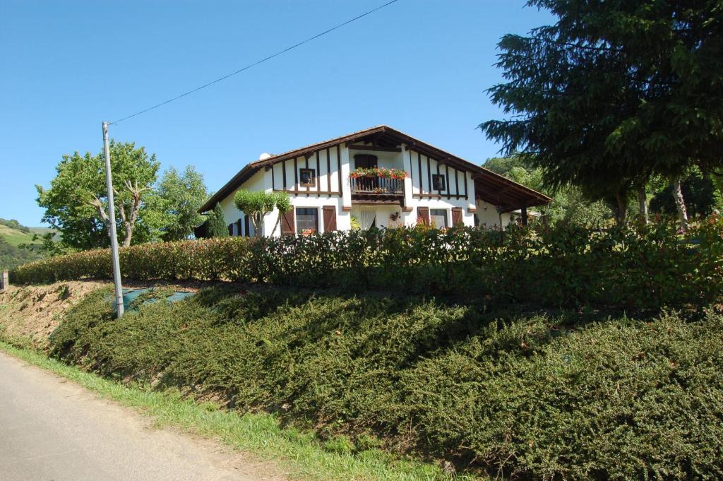 ein Haus auf einem Hügel neben einer Straße in der Unterkunft Chambres d'hôtes Esponde Marie-Jeanne in Saint-Jean-le-Vieux