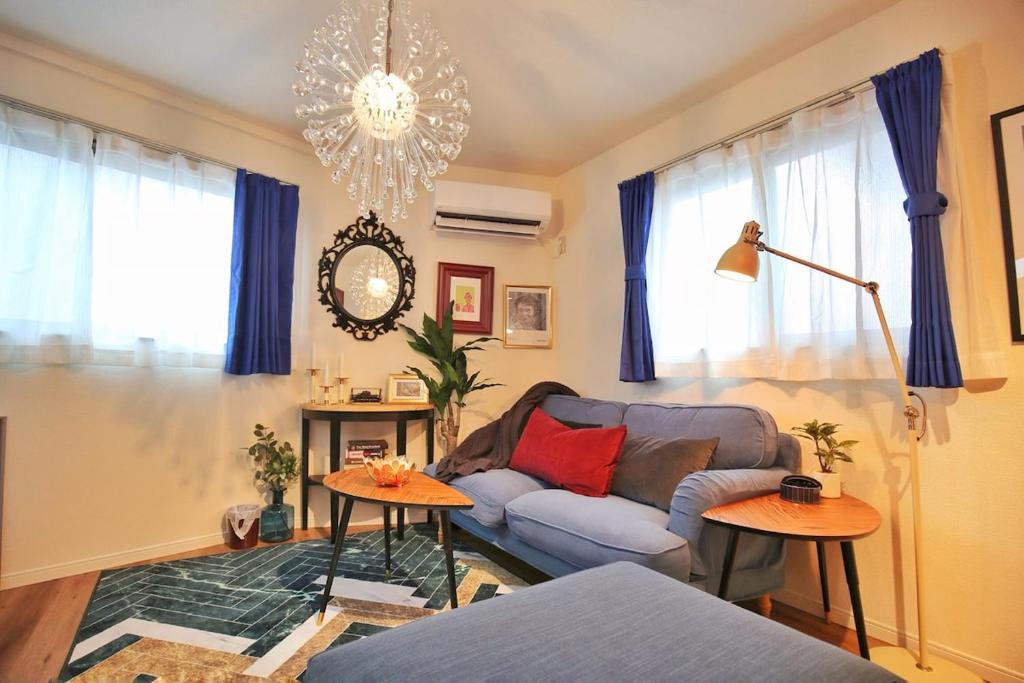 uma sala de estar com um sofá e duas mesas em SG5371 Visit Shibuya Crossing! Walking distance to a single family home for 8 people, private parking , downstairs supermarket food Shibuya em Tóquio