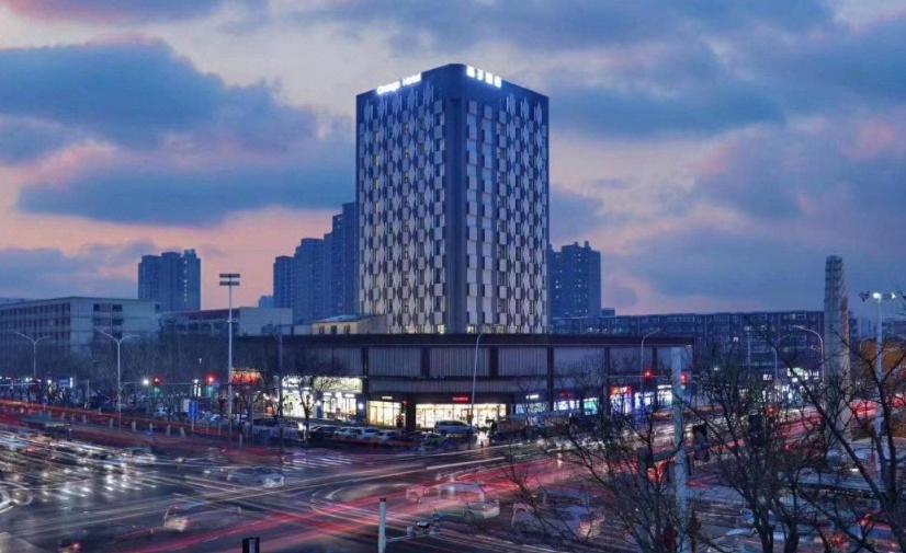 um edifício alto em uma cidade com muito tráfego em Orange Beijing Tongzhou Global Wanda Plaza Hotel em Tongzhou