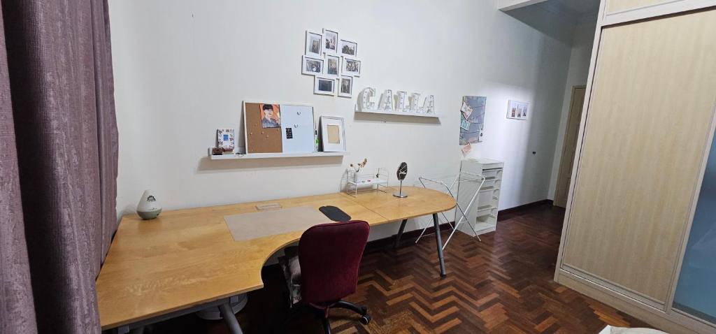 a office with a wooden desk and a red chair at CalOlie Villa in Shah Alam