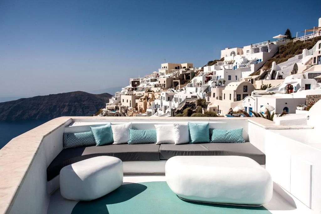 balcone con sedie e cuscini blu e bianchi di Andronikos Santorini a Imerovigli