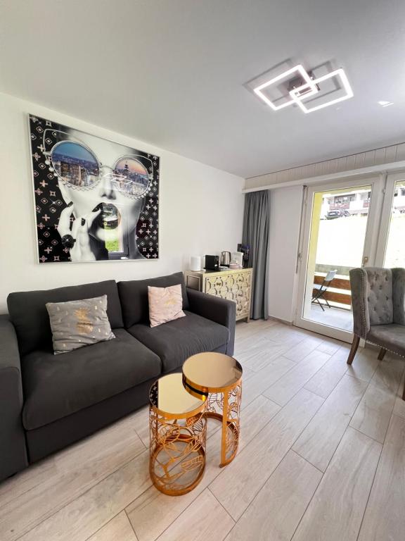 a living room with a couch and a table at Sandrina - Studio lumineux et rénové in Leukerbad