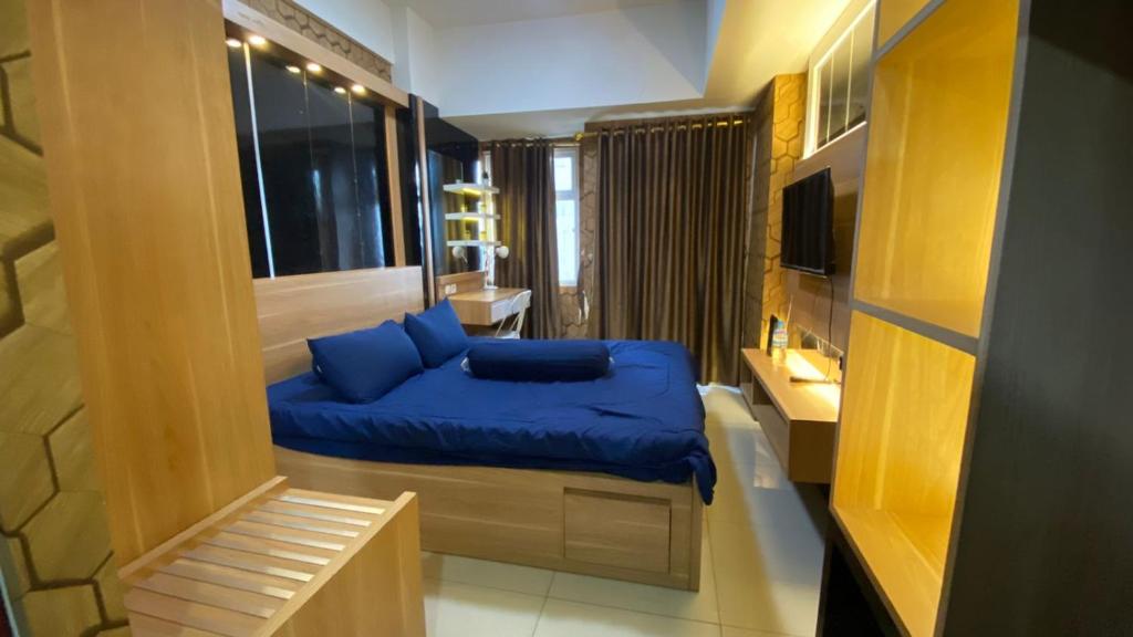 a bedroom with a blue bed in a room at Apartemen Vida View Unit 26H By Millpro in Pampang