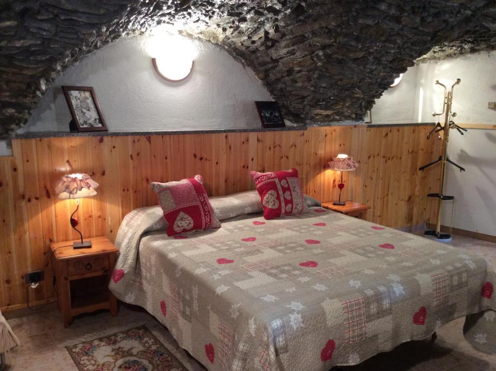 een slaapkamer met een bed en twee lampen op tafels bij B&B La Vieille Meison de Pappa in Aosta