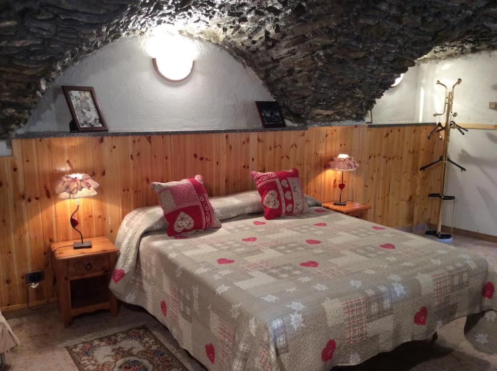 アオスタにあるB&B La Vieille Meison de Pappaのベッドルーム1室(ベッド1台、テーブルにランプ2つ付)