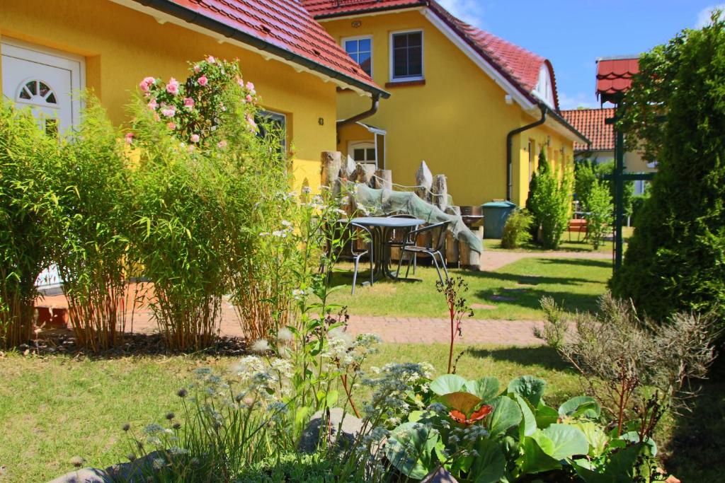 a garden with a table and chairs in front of a house at Ferienwohnungen Fründt in Prerow