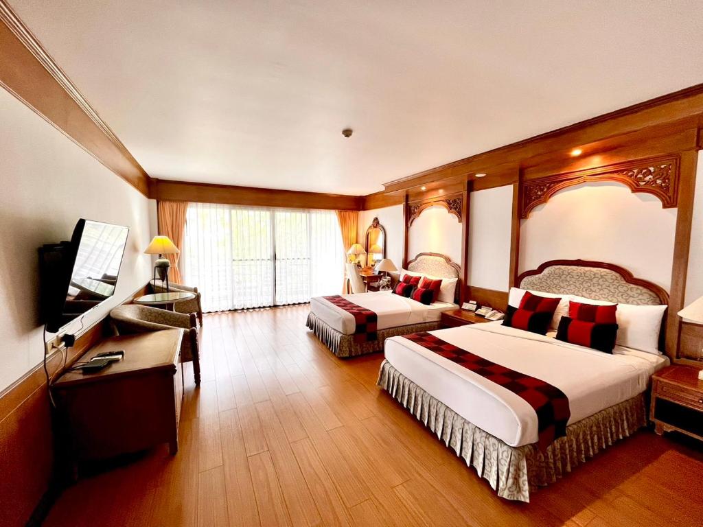 a hotel room with two beds and a flat screen tv at The Golf Lodge Hotel Laem Chabang Golf in Ban Nong Wa