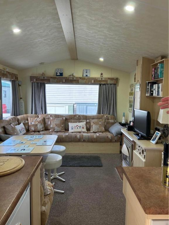 a living room with a couch and a table at Holiday home Golden Palm resort in Chapel Saint Leonards