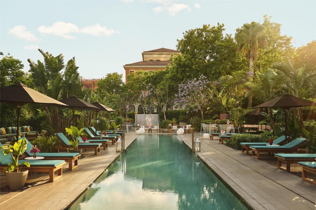 a pool with lounge chairs and umbrellas at a resort at Grand Hyatt Barcelona in Barcelona
