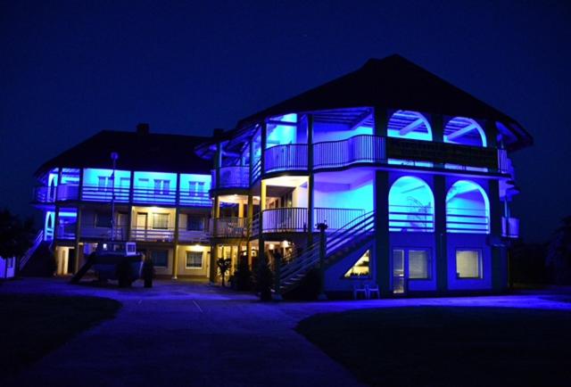 uma casa com luzes azuis à noite em Pod Złotym Żaglem em Karwia