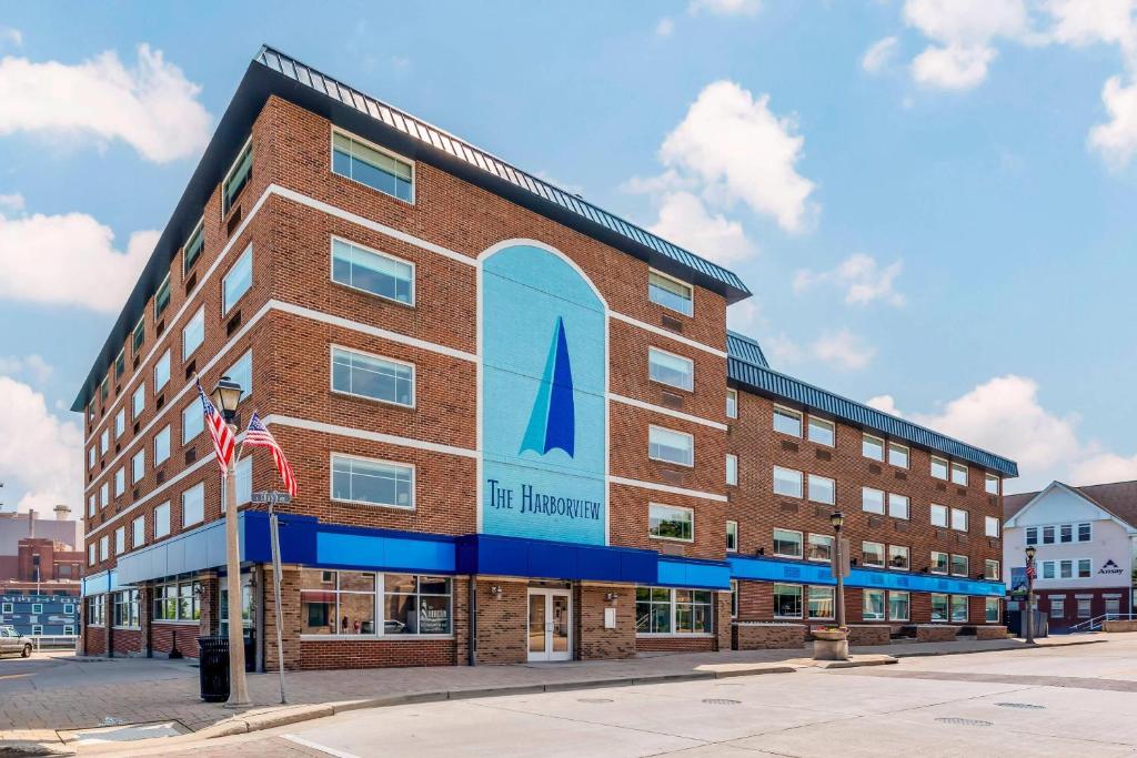 a large red brick building with a sailboat on it at The Harborview on Lake Michigan, Ascend Hotel Collection in Port Washington