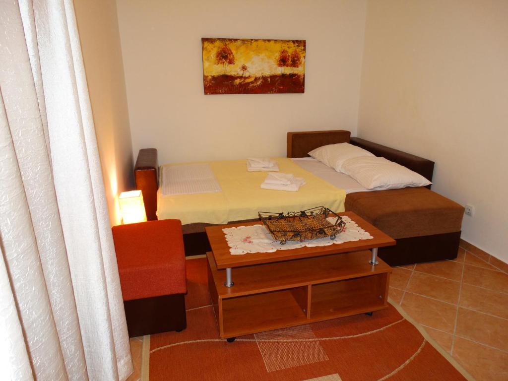 a small bedroom with a bed and a table at Apartments Ilinka in Budva