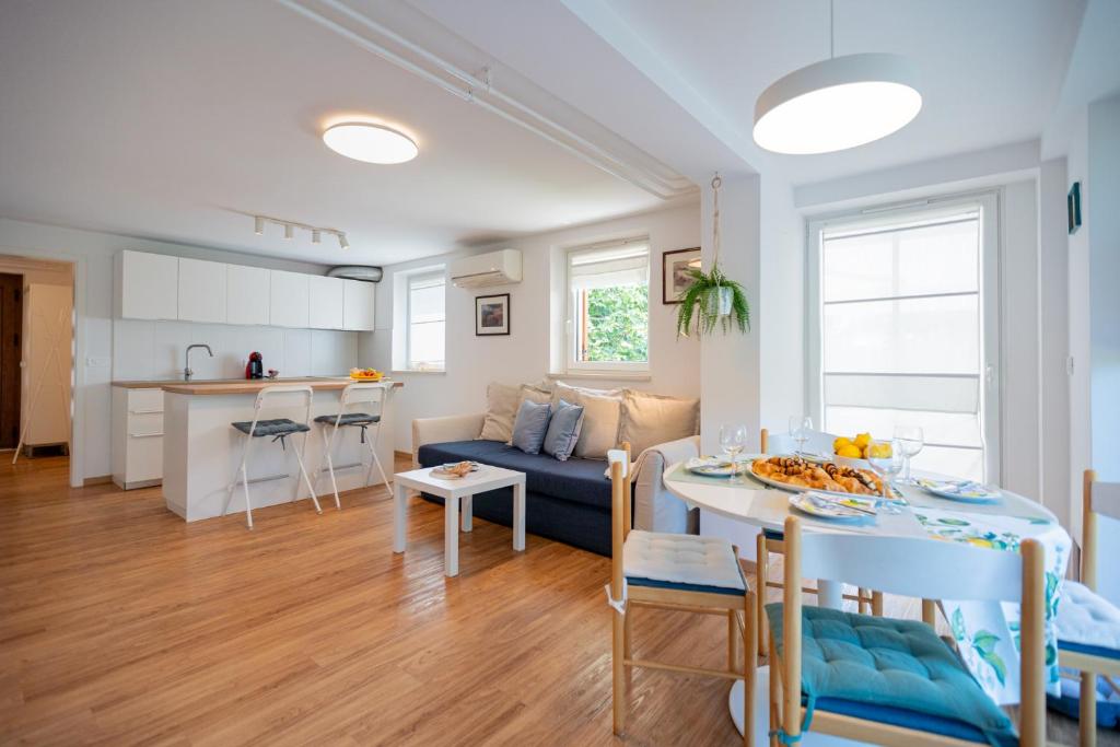 a living room and kitchen with a couch and a table at Apartment Alba with garden in Piran