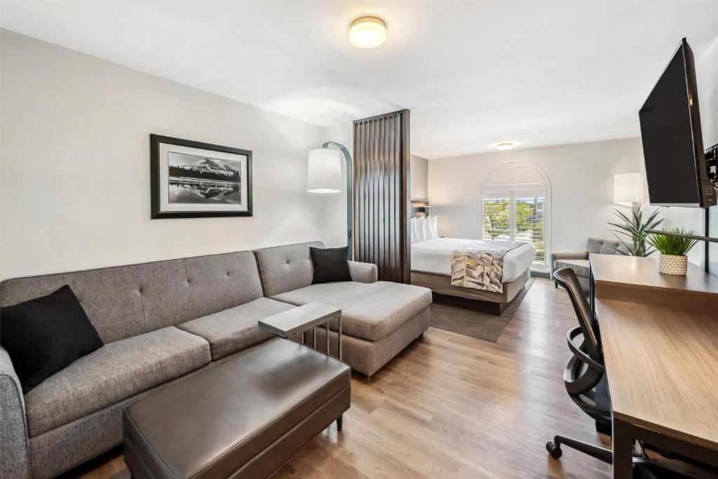 a living room with a couch and a bedroom at Best Western Plus Hilltop Inn in Redding