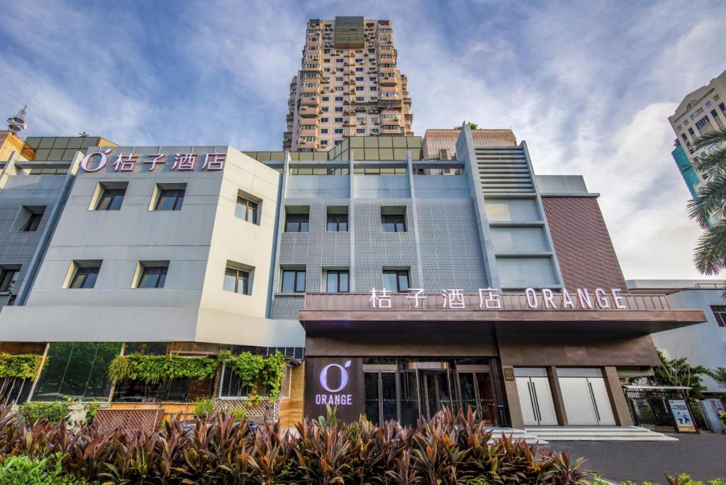 ein Gebäude vor einigen hohen Gebäuden in der Unterkunft Orange Hotel Xiamen City Hall in Xiamen