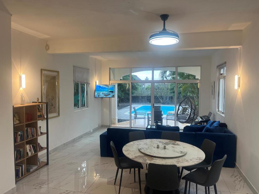 Apartment in villa with sea view في Calodyne: غرفة معيشة مع أريكة زرقاء وطاولة