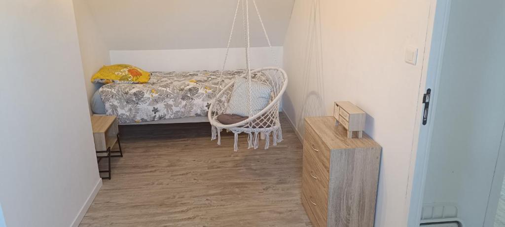 Habitación con silla mecedora y cama en Chez MaLouNa - 15 min de la Baie de Somme, en Friville-Escarbotin