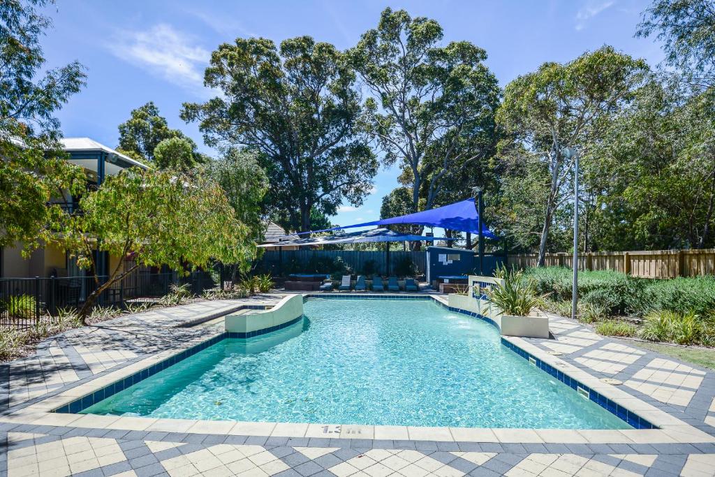 una piscina in un cortile alberato di Leeuwin Apartments a Margaret River Town