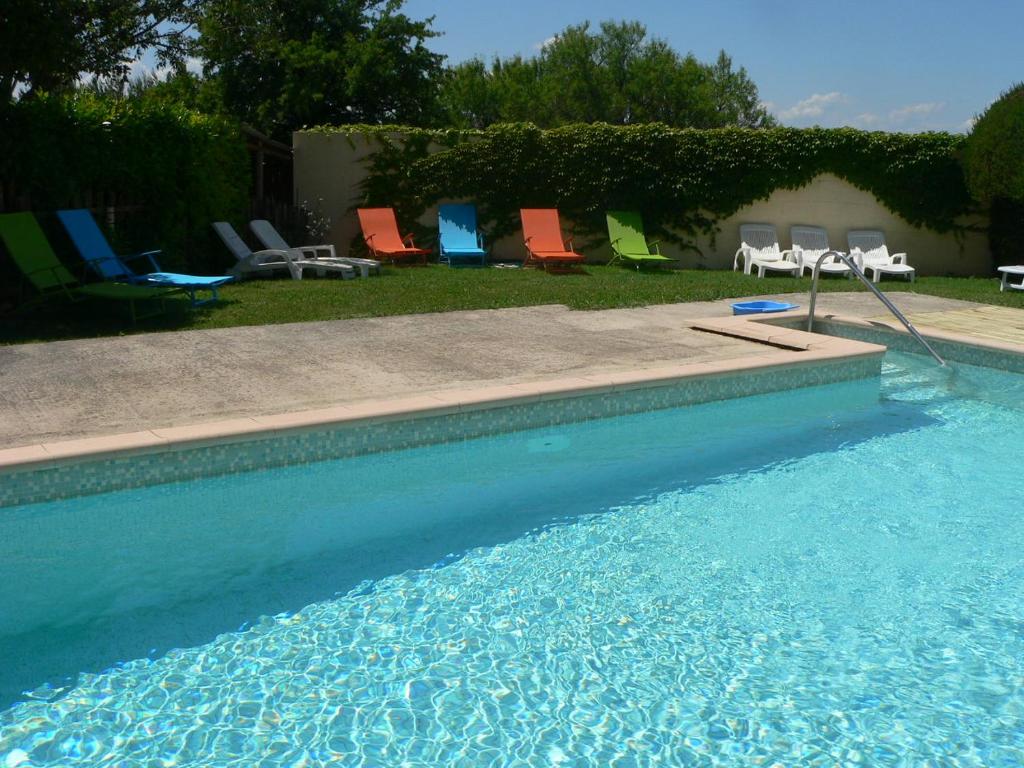 eine Gruppe Stühle und ein Pool in der Unterkunft Chambres d'Hôtes Chez Cécile in Lagnes