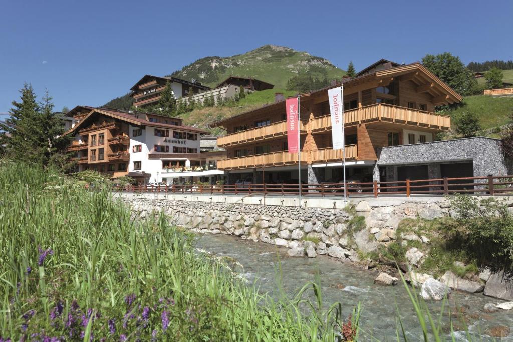um grupo de edifícios junto a um rio em Hotel Auenhof em Lech am Arlberg