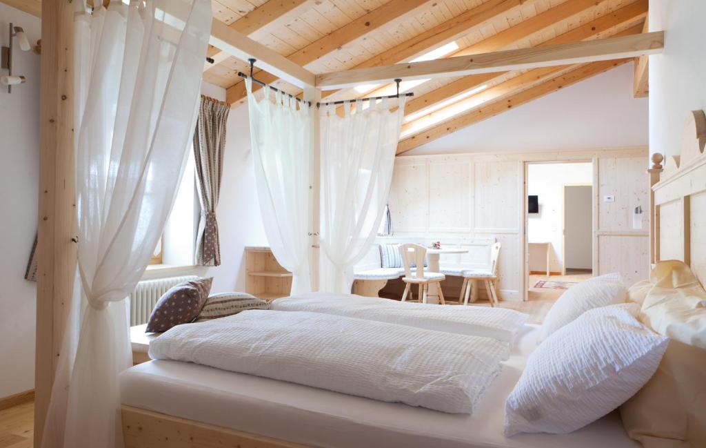 two beds in a bedroom with wooden ceilings at Coronata Haus in Roncegno
