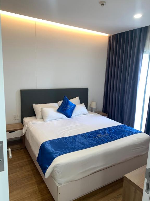 a bedroom with a large bed with blue pillows at Republic Plaza - View sân bay, view hồ bơi in Ho Chi Minh City