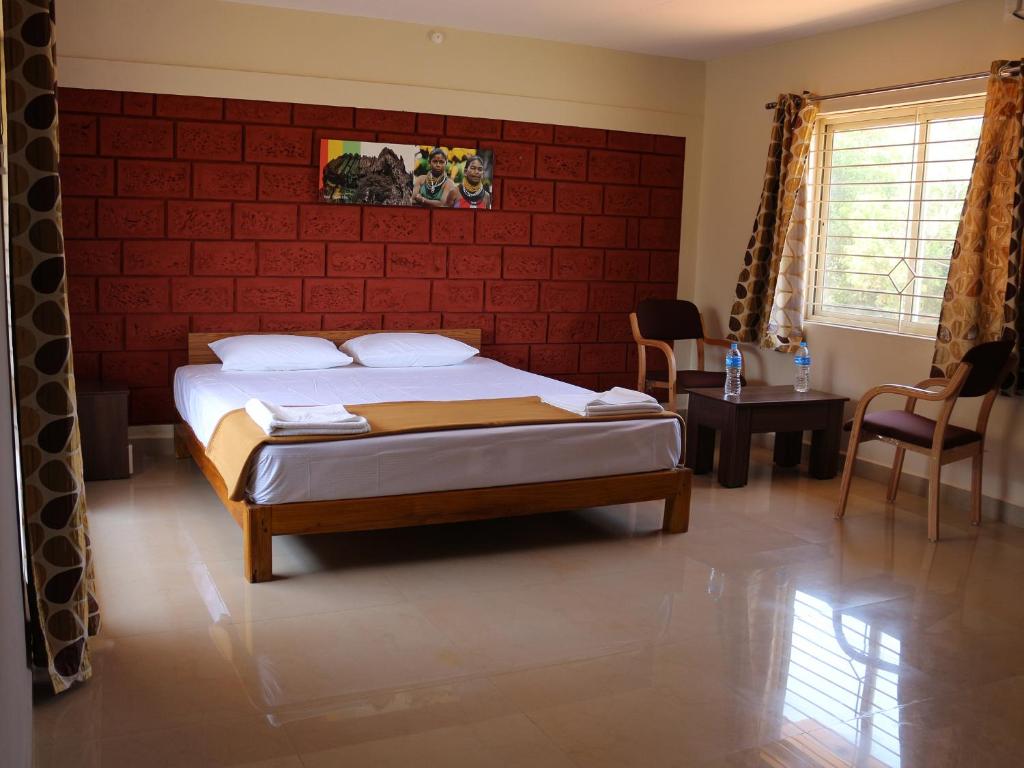 a bedroom with a bed with a red wall at Kinara Stay in Kumta