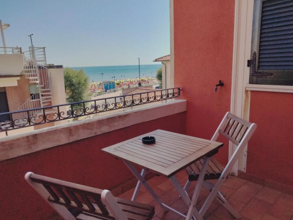 a table and chairs on a balcony with a view of the beach at Casa Prinz in Marotta
