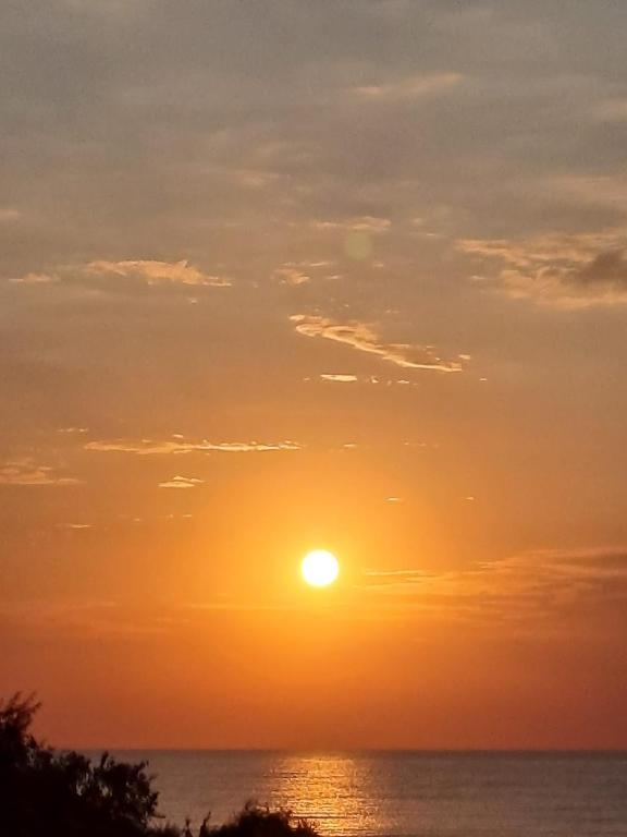 a sunset over the ocean with the sun in the sky at Selena by the sea in Mamaia